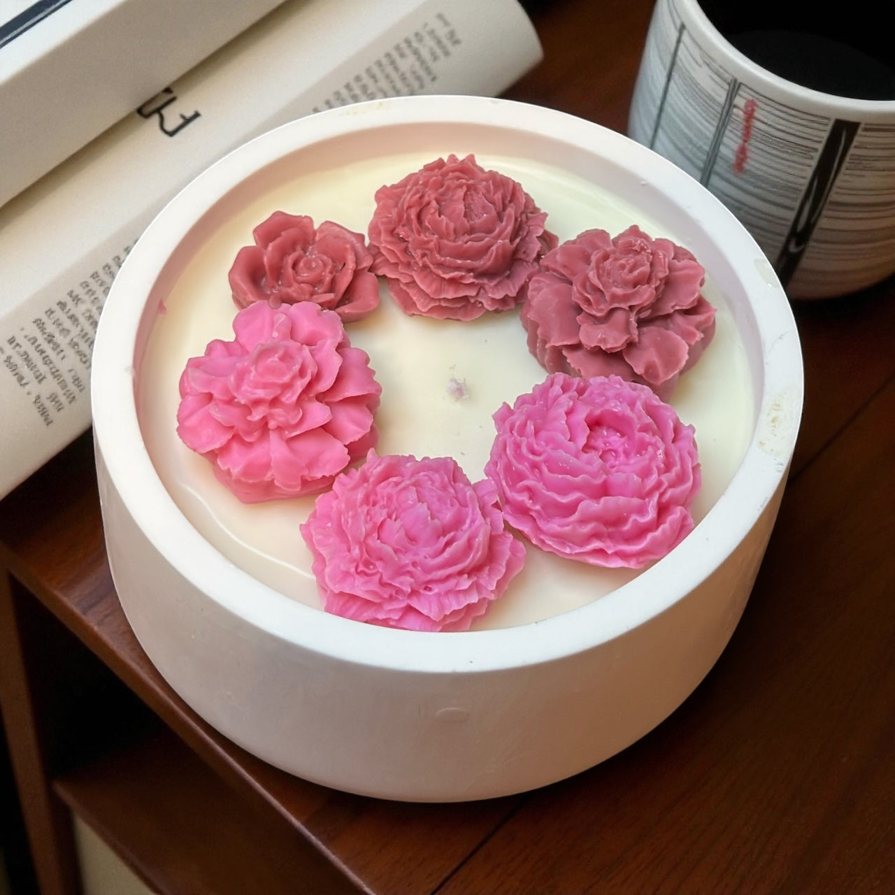 Unlit Scalloped Edge decorative candle with an asymmetrical pattern of bright yellow wax roses and dahlias. Modern soy wax floral dish on a dark wood table."