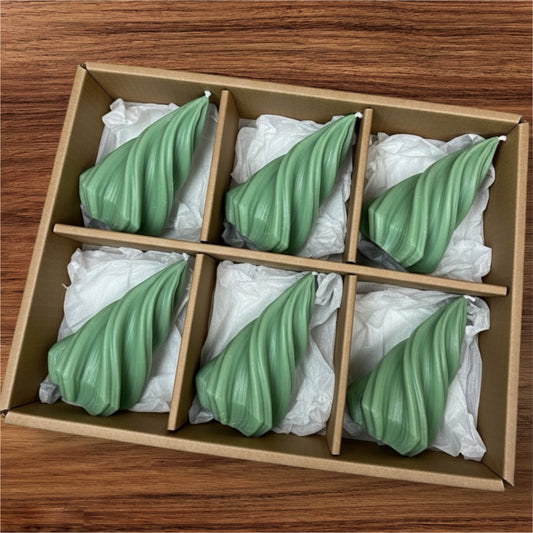 Box of six evergreen green sculptural twist candles packaged in a brown cardboard gift set, ideal bulk purchase for modern home decor or event styling.