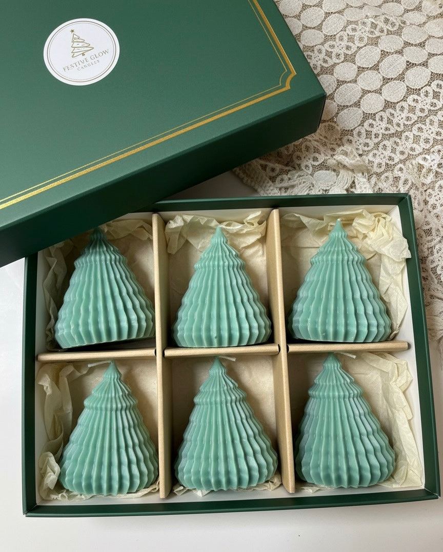 Luxury green gift box from Festive Glow Candles, containing a set of six small, sage green, pleated Christmas tree candles, individually nestled in compartments.