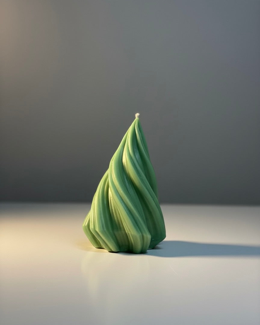 Single aesthetic green sculptural twist candle standing on a white surface with strong side lighting to emphasize the unique swirl texture.