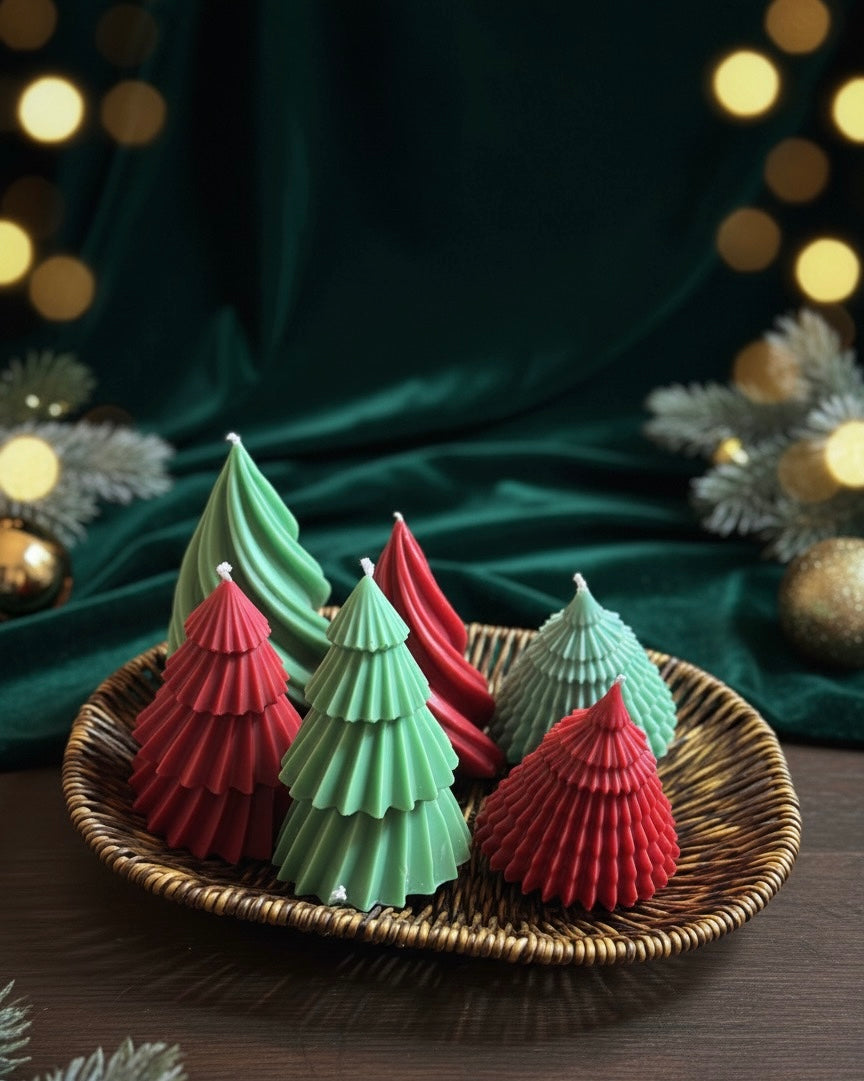 Decorative candles shaped like Christmas trees on a woven tray with a festive background.